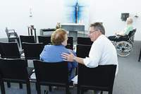 Der Seelsorger spricht mit einer Dame in der Kapelle